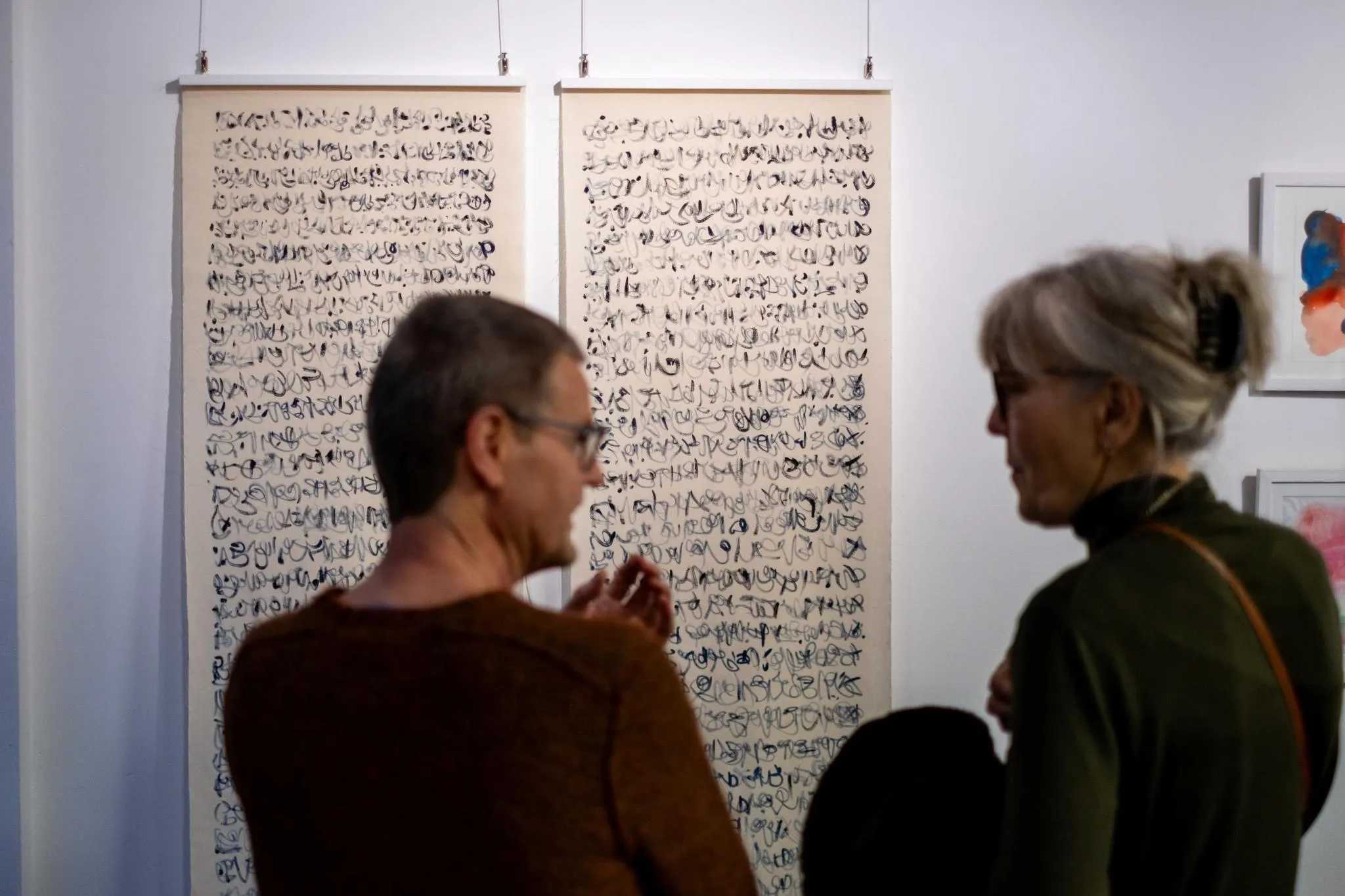 Visitors discussing in front of large-format ink scroll works