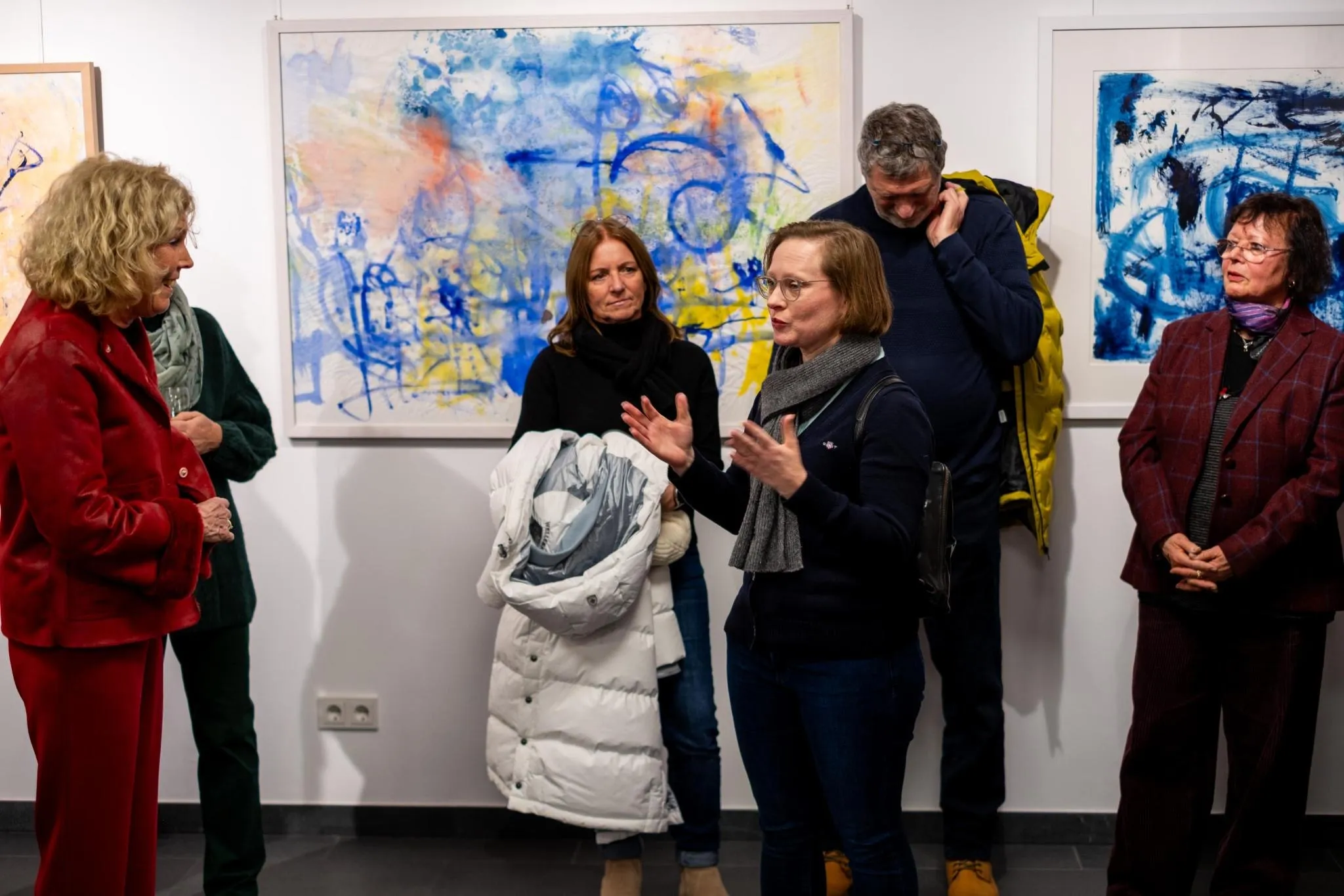 Group conversation in front of abstract paintings